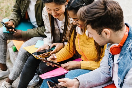 Students smiling while looking at their phones